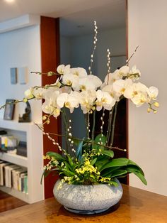 there is a vase with white flowers on the table