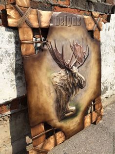 a wooden sign with an image of a moose on it