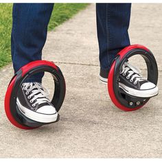 two people standing on top of red and black roller skates, one with wheels