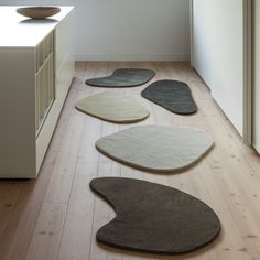 four rugs are arranged on the floor in front of a kitchen counter and sink