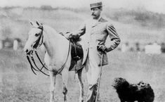 an old black and white photo of a man on a horse next to a dog