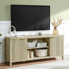 a flat screen tv mounted to the side of a wooden entertainment center in a living room