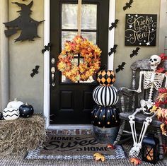 a front door decorated for halloween with pumpkins and skeletons