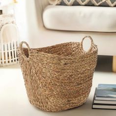 a basket sitting on top of a white table next to a book and a chair