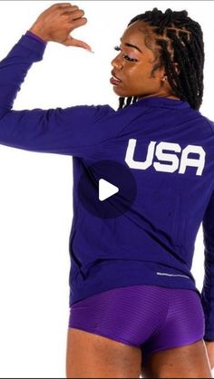 a woman with dreadlocks wearing purple shorts and a usa t - shirt on