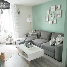 a living room filled with furniture and a cat sitting on the floor next to it