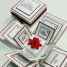 a bunch of cards with a red bow on them and some white boxes in the middle