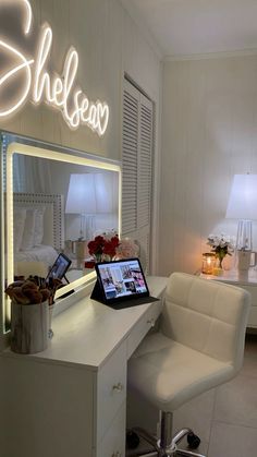 a laptop computer sitting on top of a desk in front of a lighted sign that says sheleen