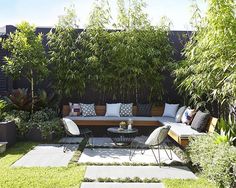 an outdoor living area with couches, tables and plants