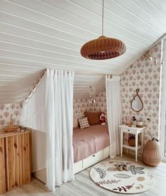 a bedroom with white curtains and pink bedding