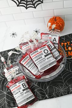 some candy bags are sitting on a table with spider webs around them and halloween decorations in the background