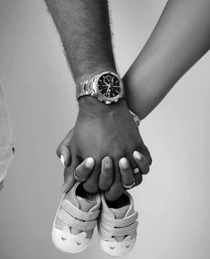 two people holding hands while wearing sneakers