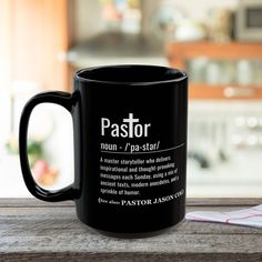 a black coffee mug sitting on top of a wooden table