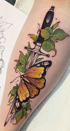 a tattoo with a knife and flowers on the side of her leg, next to a piece of paper