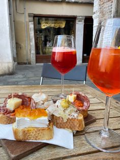 two glasses of wine and some food on a table