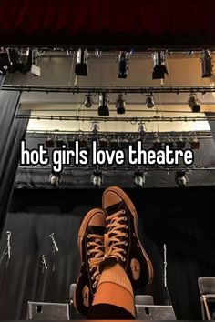 a person's feet with their shoes on in front of a set of stage lights