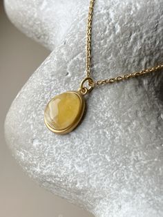 Embrace the captivating allure of the Baltic sea with this chic, elliptical amber pendant. Each piece showcases a pristine slice of natural Baltic amber, renowned for its warmth and depth, encased in a sophisticated gold-plated sterling silver frame. This pendant is the essence of elegance, designed to add a touch of timeless sophistication to any outfit. Its unique organic patterns ensure that no two pendants are alike, offering you an exclusive piece of the earth's beauty. This product is unique due to the stone and is presented as a single instance. Stone - 0.67" Size(US)- 18 Material - gold plated sterling silver and natural amber Luxury Amber Necklace With Polished Finish, Amber Pendant With Large Stone, Yellow Gold Cabochon Teardrop Pendant Necklace, Gold Cabochon Teardrop Pendant, Gold Cabochon Teardrop Pendant Jewelry, Gold Teardrop Cabochon Jewelry, Gold Baltic Amber Necklace For Gift, Elegant Oval Amber Necklaces, Luxury Amber Oval Necklace