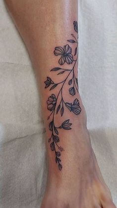 a woman's foot with a flower tattoo on it