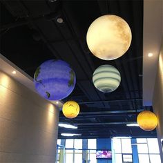 four different colored paper lanterns hanging from the ceiling