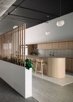 an open kitchen and dining area with wooden slats on the wall, along with potted plants