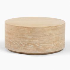 a round wooden table sitting on top of a white floor