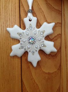 a white snowflake ornament hanging from a wooden door