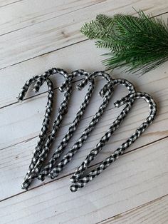 the black and white gingham umbrella is next to a pine branch on a wooden table