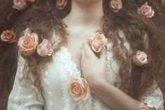 a woman with long brown hair and pink roses on her head is wearing a white dress