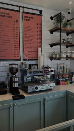 there are menus on the wall above the coffee machine in this restaurant's kitchen