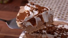 there is a piece of cake with chocolate and whipped cream on it, being held up by a fork