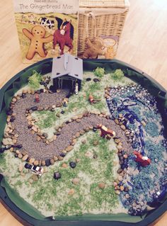 a toy train set sitting on top of a table next to a book and basket