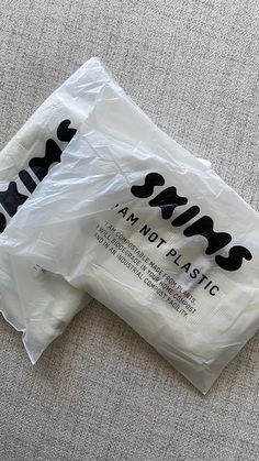 two plastic bags sitting on top of a carpeted floor next to a white wall