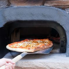 a pizza being cooked in an oven with a spatula