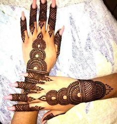 two hands with henna tattoos on them