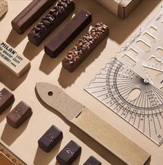 various chocolates are arranged on a table next to a ruler, knife and other items