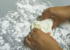 a person is kneading some food on a table with snow all over it