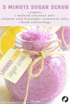 a jar filled with pink bath salts next to lemons