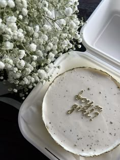 a cake with the word joy spelled on it next to a bouquet of white flowers