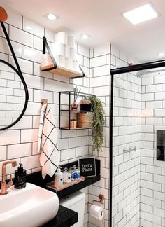 a bathroom with black and white tiles, a sink, shower stall and shelves on the wall