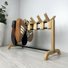 two pairs of shoes are hanging on a rack in front of a potted plant