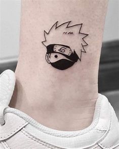 a small tattoo on the ankle of a person with a helmet and lightning bolt in the background