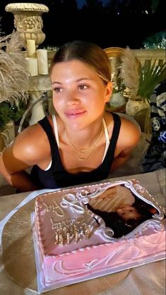 a woman sitting at a table in front of a cake