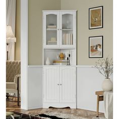 a living room with white furniture and pictures on the wall above it's shelves