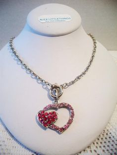 Pink double heart necklace. It measures approx. 19 inches and has a toggle clasp closure. Made with a light pink rhinestone heart silhouette and a smaller solid hot pink rhinestone heart. Silver tone. Perfect for give or wear on Valentine's Day. All sales are final and as is. Thank you for looking. You may also love this: https://www.etsy.com/listing/584789387/heart-silhouette-pendant-necklace?ref=shop_home_active_1 Valentines Day Costume, Pink Heart Pendant, Heart Silhouette, Double Heart Necklace, Carnelian Ring, Rhinestone Heart, Lovely Necklace, Lovely Earrings, Pink Rhinestones