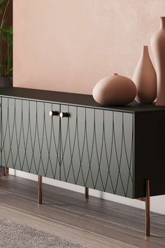 two vases are sitting on top of a black and white cabinet in front of a pink wall