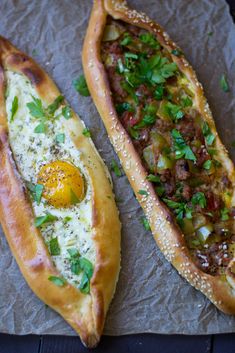 two pieces of bread with an egg in the middle and other food items on top