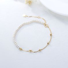 Discover the elegance of our 14K Gold Bead Station Chain Bracelet, designed exclusively for women who appreciate the timeless beauty of pearls and gold beads, perfect for adding a touch of sophistication to any ensemble.DetailsOur exquisite bracelet features lustrous pearls and radiant gold beads strung along a delicate 14K gold chain, offering a luxurious yet understated accessory for any occasion. Ideal for the modern woman, this bracelet combines classic materials with contemporary design, en Elegant Beaded Rosary Bracelet, Elegant Pearl Rosary Bracelet With Round Beads, Pearl Chain Beaded Bracelets, Pearl Beaded Bracelets With Round Beads, Pearl White Pearl Beaded Jubilee Bracelets, Elegant Pearl Rosary Bracelet With Pearl Charm, Elegant Pearl White Rosary Bracelet With Round Beads, Pearl White Pearl Beaded Jubilee Bracelet, Elegant Beaded Chain Bracelets