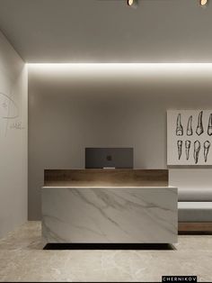 a white marble reception desk in a modern office space with an apple computer on the counter