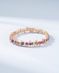 Experience the Bold Burst Rainbow Sapphire Tennis Bracelet, a striking creation that harmoniously blends 7.58 carats of rainbow sapphire baguettes with 2.12 carats of glistening baguette and round G VS diamonds. Each sapphire, cut into sleek baguettes, is set in 18k gold, showcasing a vibrant cascade of colors. Whether gracing a gala or elevating your everyday wardrobe, this tennis bracelet promises to be a treasured addition to your jewelry collection. Details 18k rose gold or yellow gold 7.58 Luxury Multicolor Baguette Diamond Jewelry, Luxury Multicolor Cubic Zirconia Tennis Bracelet, Luxury Yellow Gold Baguette Tennis Bracelet, Rainbow Tennis Bracelet, Luxury Elegant Rainbow Tennis Bracelet, Rainbow Sapphire Bracelet, Rainbow Sapphires, Vs Diamond, Tennis Bracelet