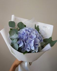 a person holding a bouquet of blue flowers